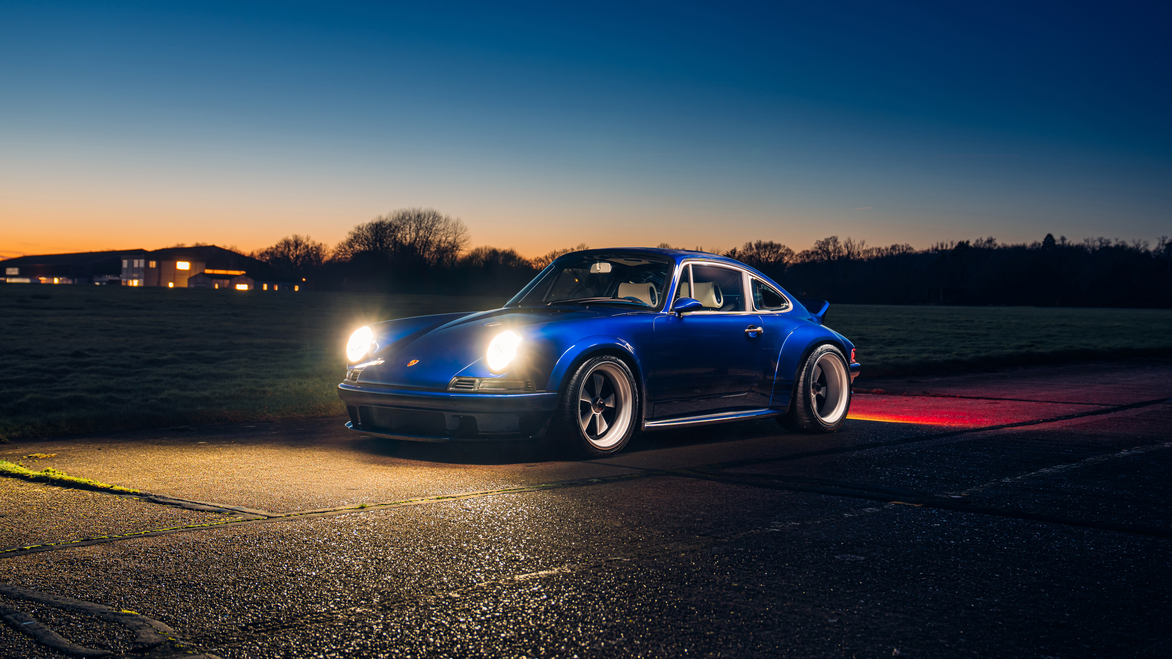 Image of an Blue Porsche standing in the sunset